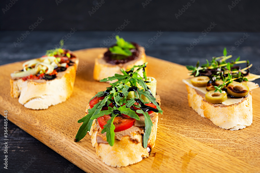 Bruschetta with chicken liver paste. Delicious bruschettas with various fillings. Different bruschetta ob wooden background Bruschetta with chicken liver paste. Delicious bruschettas with various fillings. Different bruschetta ob wooden background