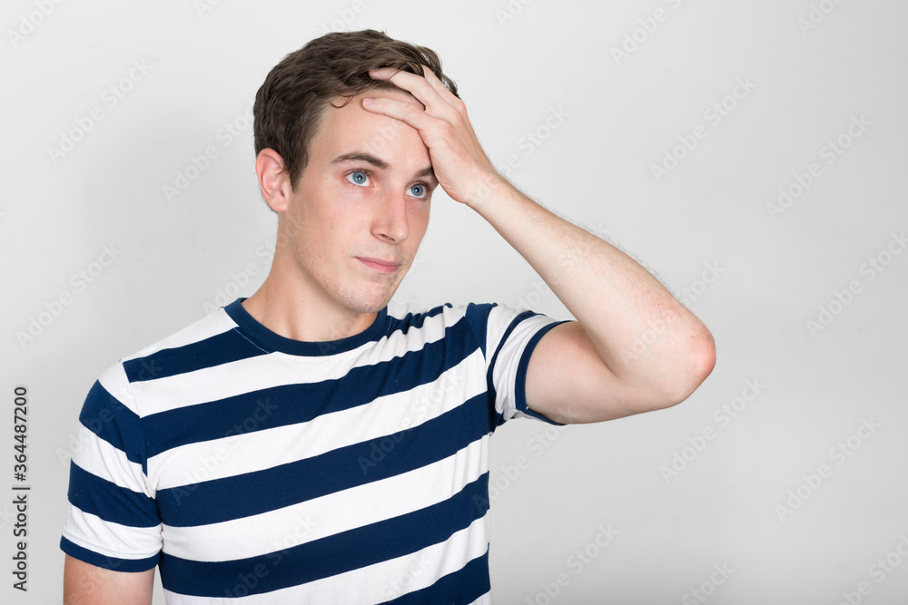 Portrait of stressed young man scratching head and looking confused Portrait of stressed young man scratching head and looking confused