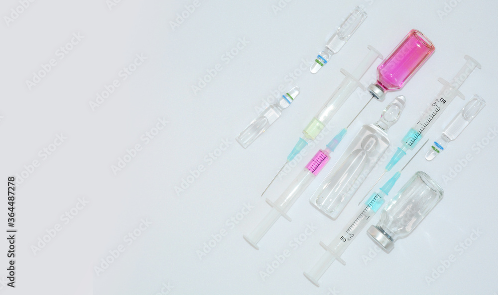 Medical background with vaccine, ampoules,
syringes and tablets. Coronavirus Covid-19 pandemic concept Medical background with vaccine, ampoules,
syringes and tablets. Coronavirus Covid-19 pandemic concept