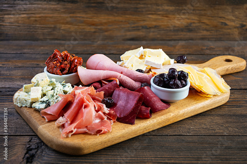 Italian antipasto. Antipasti board with ham, salsami, prosciutto, parmesan, blue cheese and olives.