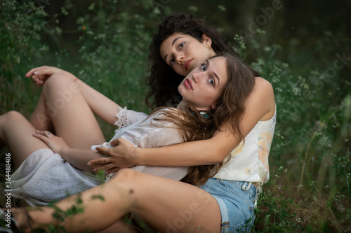 Beautiful girls posing together on forest background