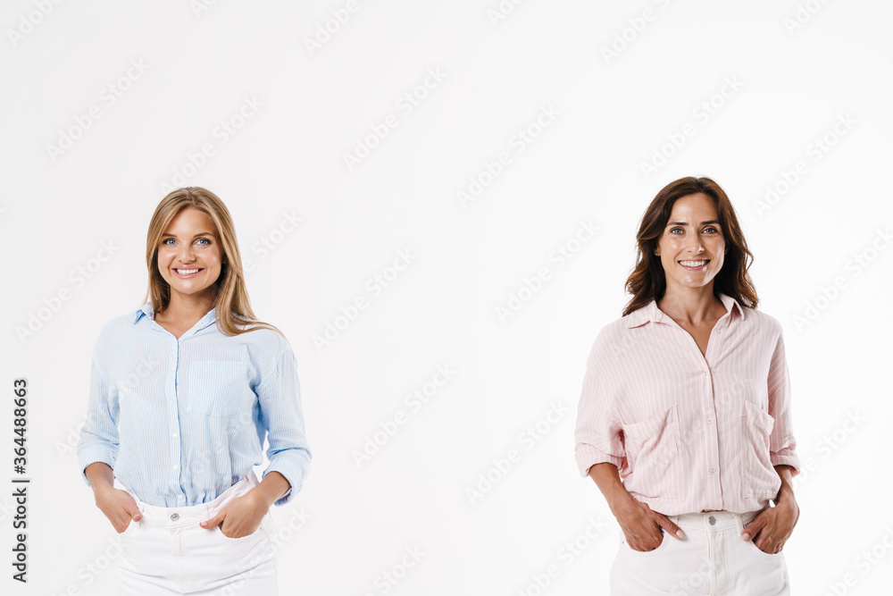 Image of cheerful caucasian two women posing and smiling at camera Image of cheerful caucasian two women posing and smiling at camera