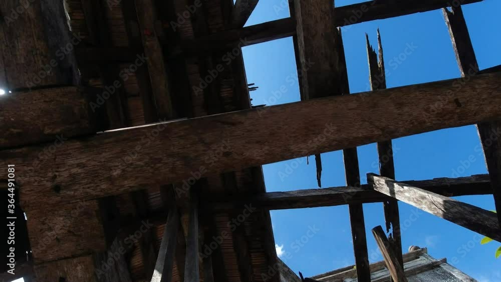 Bottom view of the roof of an old building with wooden structures against the sky. Destroyed wooden roof in the abandoned building. Steadicam shot.