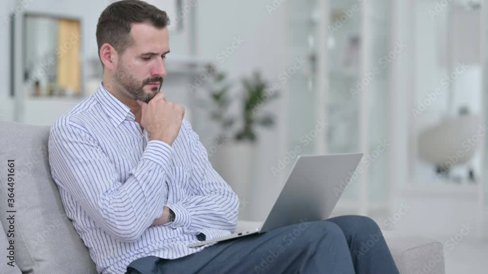Pensive Young Man using Laptop at Home Pensive Young Man using Laptop at Home