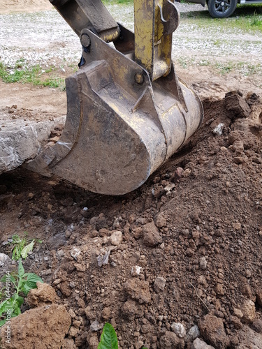 Tractor bucket digs the ground