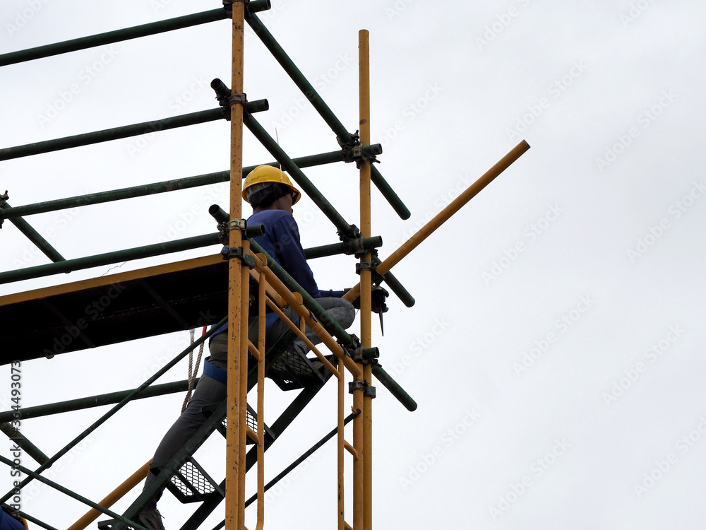 Man Working on the Working at height on construction site with blue sky Man Working on the Working at height on construction site with blue sky