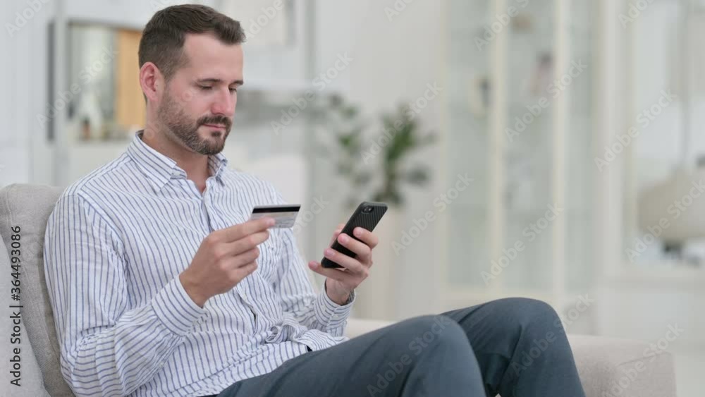 Young Man making Successful Online Payment on Smartphone Young Man making Successful Online Payment on Smartphone
