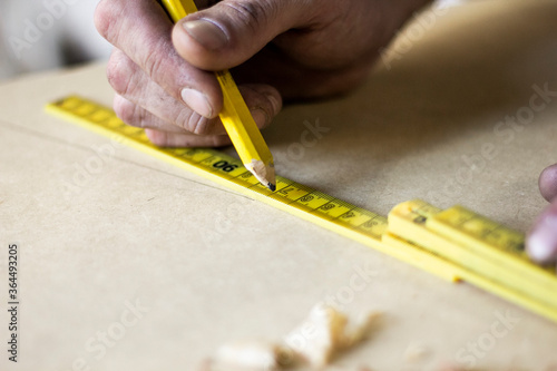 Carpenter hands working and measuring