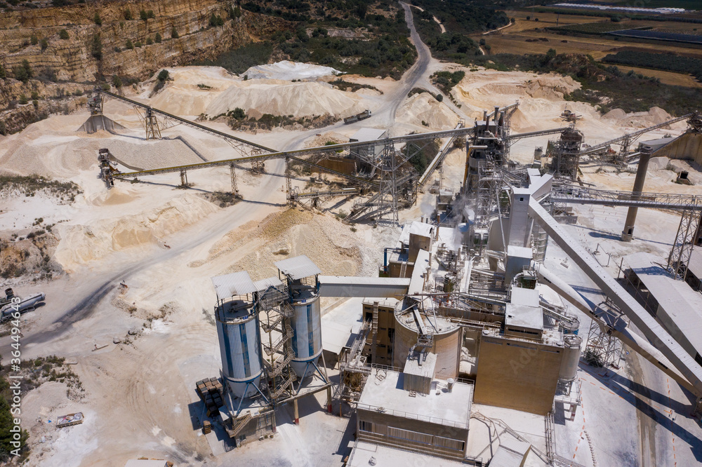 Aerial view of a large Quarry during work hours with Stone sorting conveyor belts and an open pit mine.
