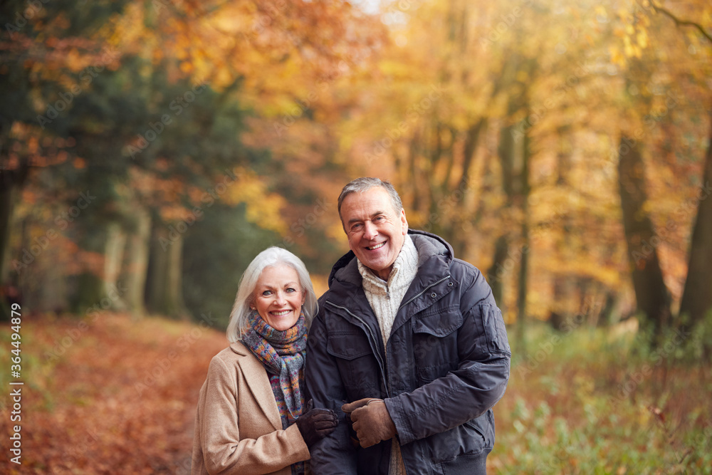 Portrait Of Loving Senior Couple Walking Along Autumn Woodland Path Through Trees Portrait Of Loving Senior Couple Walking Along Autumn Woodland Path Through Trees