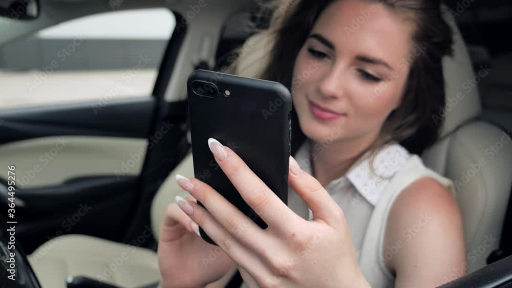 Close up finger view of A Young caucasian Woman using smartphone surfing flipping news Internet in the car on parking 4k Close up finger view of A Young caucasian Woman using smartphone surfing flipping news Internet in the car on parking 4k