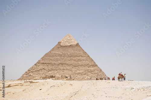 great pyramids of giza  Egypt. Scenic view from the desert. Unesco heritage location. Famous archeology landmark. Ancient architecture of the pyramids. With people in the distance.