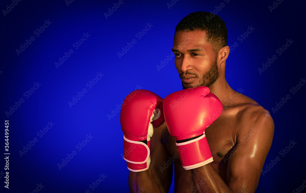 Shirtless Professional Boxer Standing In Ready-To-Fight Position On Blue Background