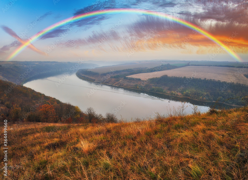 colorful rainbow over river canyon colorful rainbow over river canyon