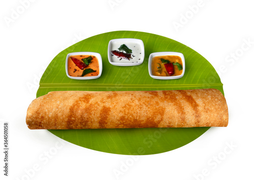 south Indian breakfast masala dosa, plain dosa ,with coconut chutney, red chutney, and sambar served on banana leaf 