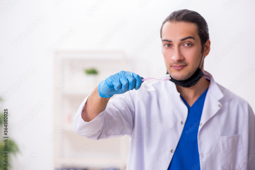 Naklejka premium Young male dentist working in the clinic