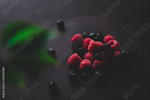 Fototapeta Naklejka Na Ścianę i Meble -  Fresh blueberries with leaves and raspberries