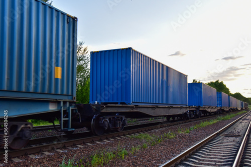 Cargo Containers Transportation On Freight Train By Railway. Intermodal Container On Train Car. Rail Freight Shipping Logistics Concept. Import - export goods from Сhina. Motion, Out of focus