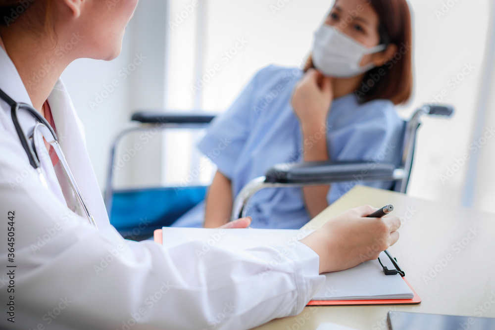 Beautiful young Asian female doctor is recording a medical history on the clipboard and explaining something to the female patient. Medical and health care concepts Beautiful young Asian female doctor is recording a medical history on the clipboard and explaining something to the female patient. Medical and health care concepts