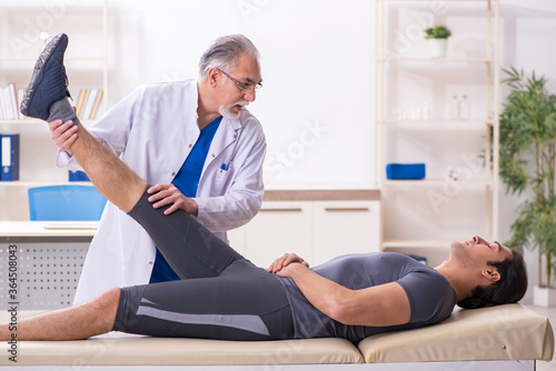 Young male patient visiting old doctor traumatologist