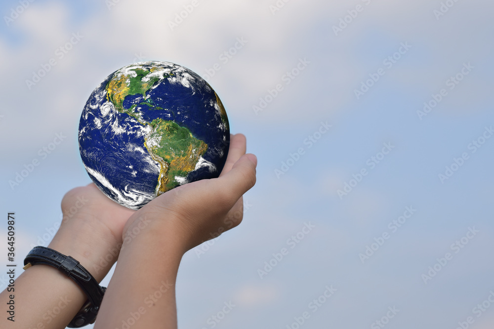 Environment concept. Hand holding globes over blue sky background. Elements of this image furnished by NASA Environment concept. Hand holding globes over blue sky background. Elements of this image furnished by NASA
