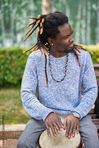 Photography handsome talented black guy enjoys performing music for public audience in the streets