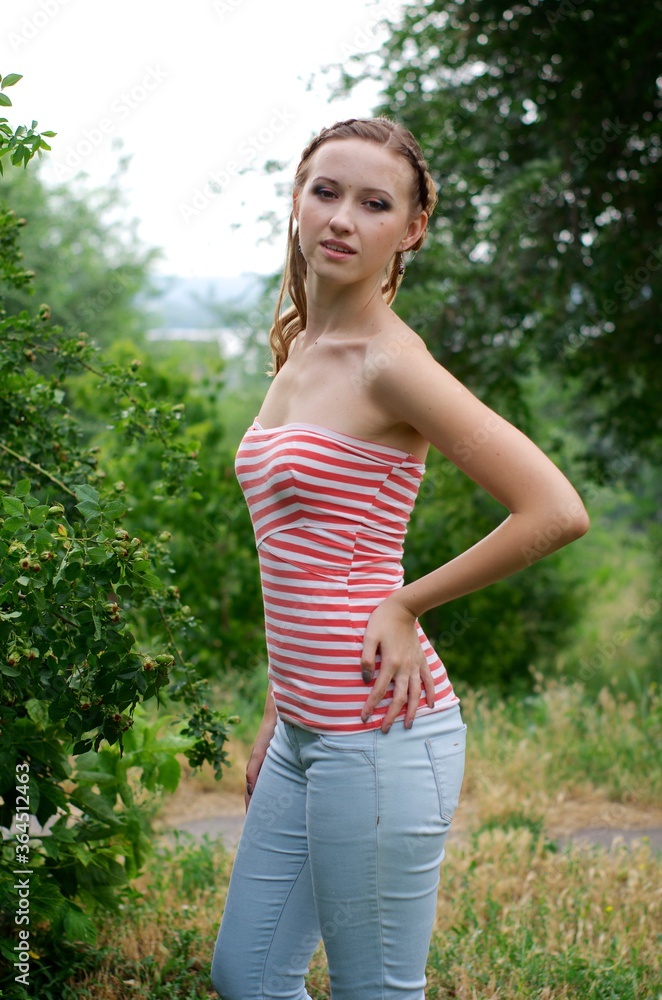 The beautiful girl is walking outdoors. Girl in the park. Girl on nature. Woman outside. Positive woman smiling The beautiful girl is walking outdoors. Girl in the park. Girl on nature. Woman outside. Positive woman smiling
