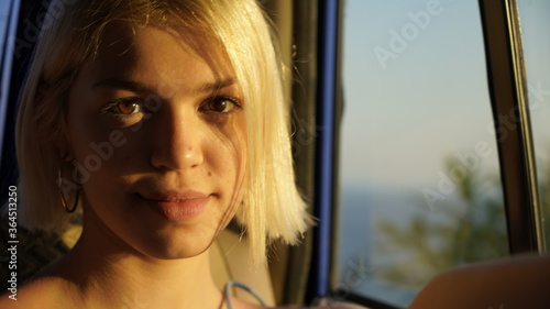Beautiful happy blonde woman smiles and looking to camera in the car