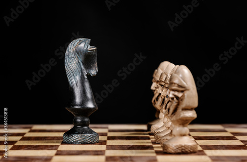 pawn chess pieces facing the knight on a chessboard