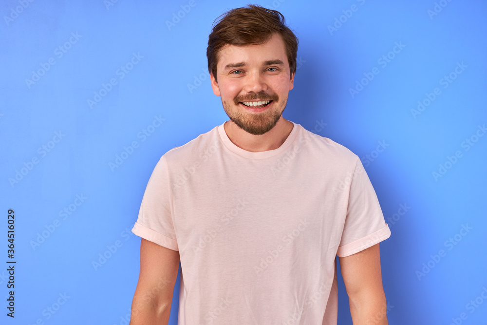 young handsome man with beard wearing casual shirt standing over blue background, happy face smiling,looking at the camera. positive person. young handsome man with beard wearing casual shirt standing over blue background, happy face smiling,looking at the camera. positive person.