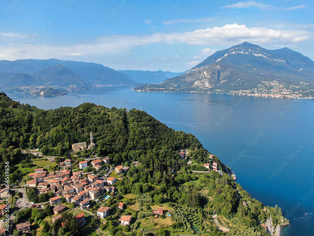 beautiful village at lake como during summer aerial panorama between dervio and bellano with lake and mountains in background