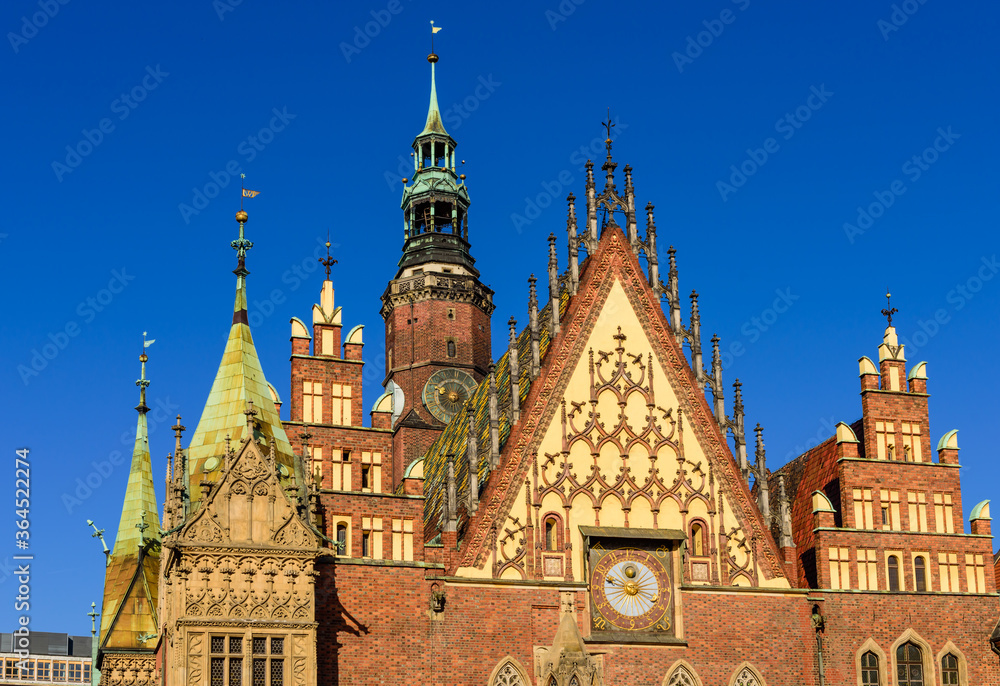 Fototapeta premium Sightseeing of Wroclaw, Poland. City hall of Wroclaw - the monument of architecture in the Gothic style. Detail of the facade with an astonomical clock.