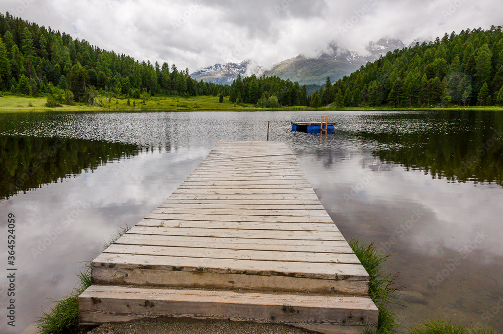 Fototapeta premium St.Moritz, Stazersee, górskie jezioro, Stazerwald, drewniana kładka, jezioro kąpielowe, zabawa w kąpieliskach, Engadyna, Górna Engadyna, Alpy, Piz Nair, Piz Julier, Gryzonia, lato, Szwajcaria