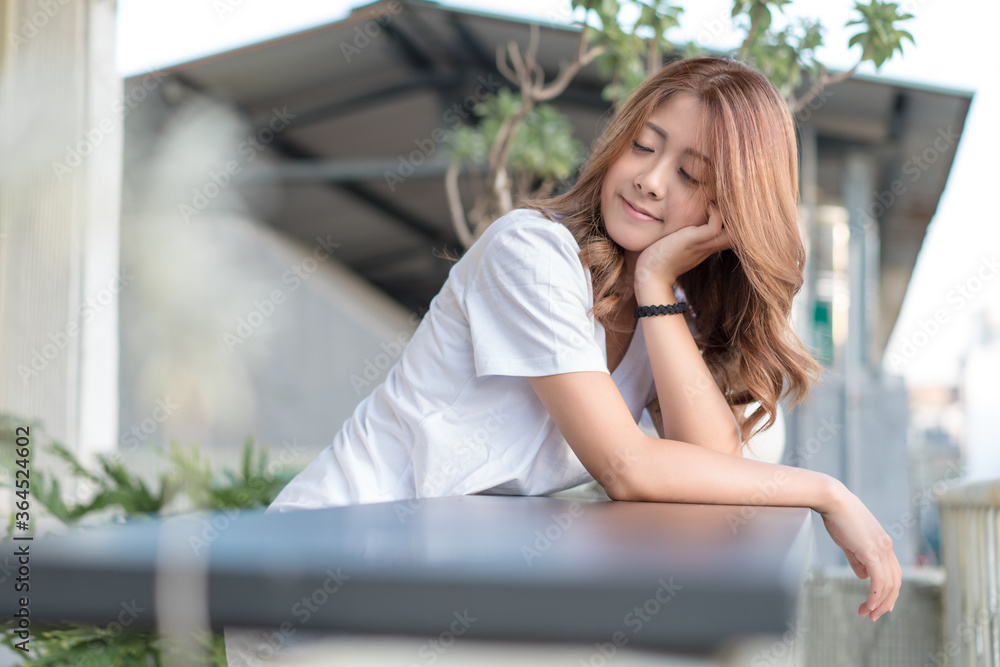 Slim well-dressed girl looking at city from balcony. Woman enjoy her coffee at the balcony.