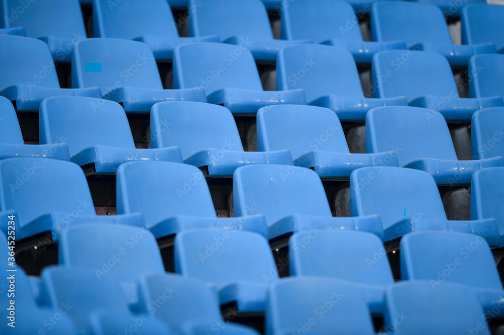 Fototapeta premium Empty soccer stadium tribune. As a safety measure during corona virus pandemic, soccer matches are taking place without public