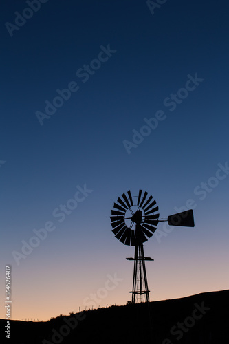Windpomp/Windmill silhouette against the fast approaching dawn over the Tankwa karoo in South Africa