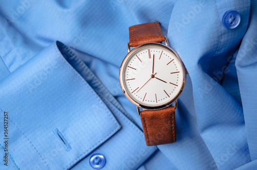 Men's stylish watch on a blue shirt. Stock photography for business