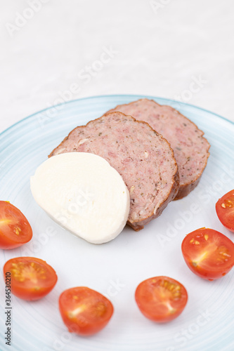 Sliced Meatloaf served with cheese and cherry tomatoes