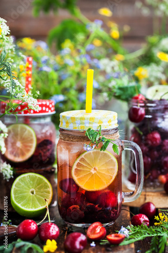 Healthy homemade cold lemonade with fresh berries and fruits in mason jar