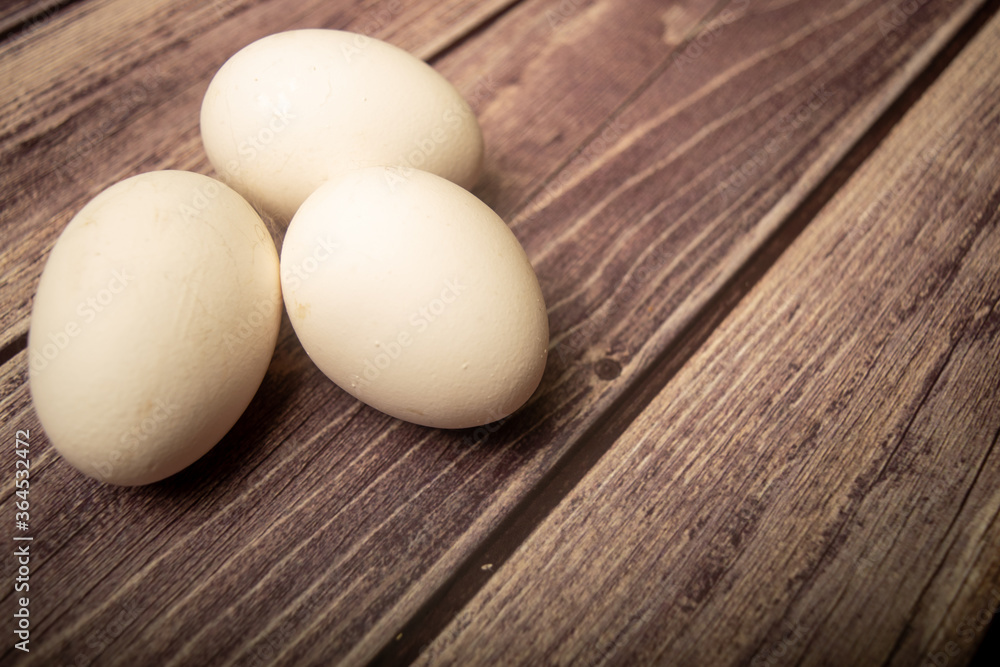 White chicken eggs on a wooden background. Close up. White chicken eggs on a wooden background. Close up.