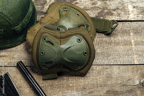 Military knee pads on wooden surface close up