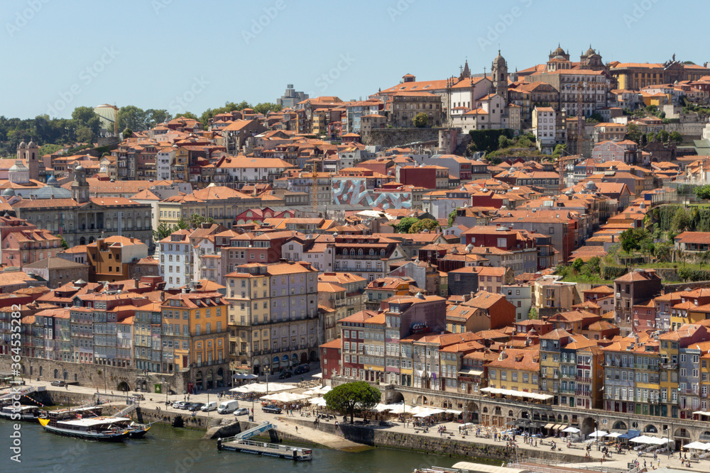 Colorful houses of Porto Ribeira, traditional facades, old multi-colored houses with red roof tiles on the embankment in the city of Porto, Portugal. Unesco World Heritage site.