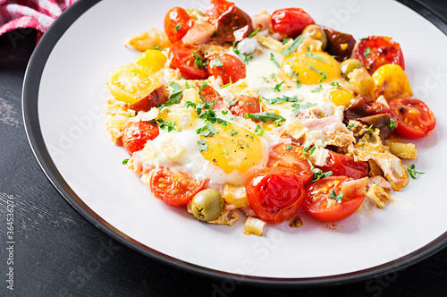 English breakfast - fried eggs, ham, tomatoes and arugula. American food.