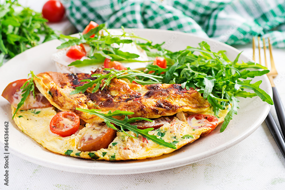 Omelette with tomatoes, cheese and green herbs on plate. Frittata - italian omelet. Omelette with tomatoes, cheese and green herbs on plate. Frittata - italian omelet.