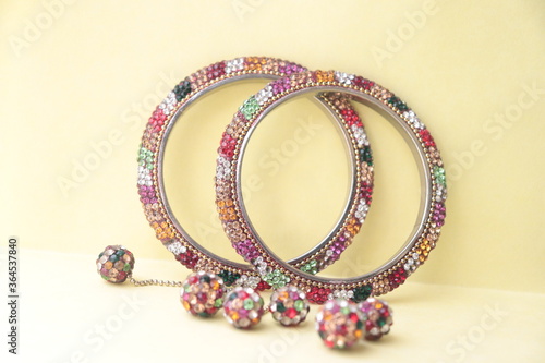 Indian traditional multi-color rhinestone type imitation bangles with hangings to the bangles.