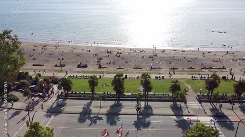 Canadian Flag with LGBTQ and Pride flags over looking a sunny summer day when peoiple are respecting physical distancing at English Bay Beach in vancouver Canada. photo