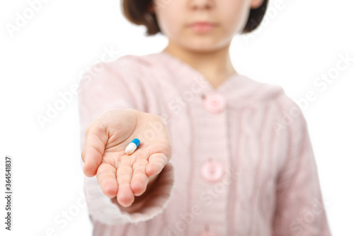 Child holds in the palm a pills. photo