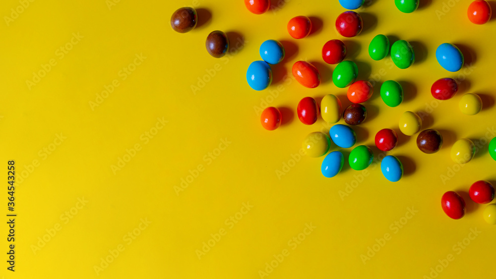 Multi-colored sweets on a yellow background. Copy space. Multi-colored sweets on a yellow background. Copy space.
