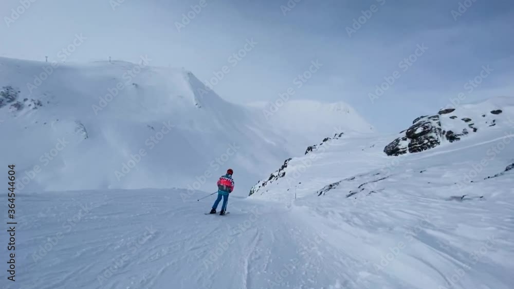 Skier riding downhill on snowy slope. Skier riding downhill on snowy slope.
