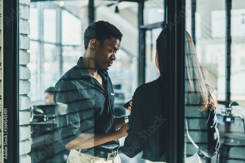 Fotografija Serious african american male roud ceo discussing working plan with female employee dressed in formal wear